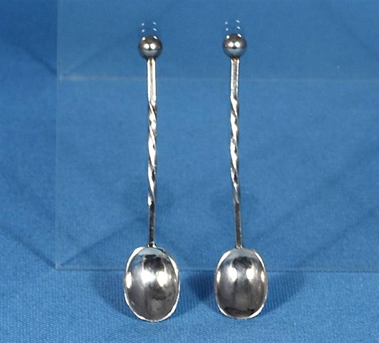 A pair of George V Arts & Crafts silver mustard pots with matching spoons, by Albert Edward Jones, width 90mm, weight 5.1oz/160grms.